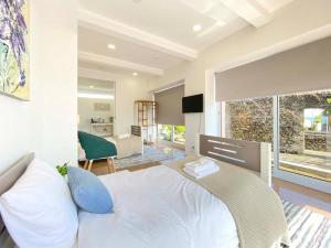 a bedroom with a white bed and a large window at Capelas House Family in Capelas
