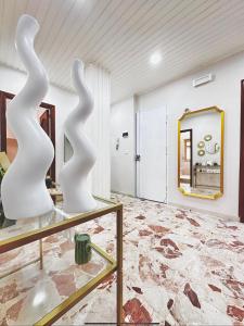 2 esculturas blancas expuestas en una habitación con espejo en Etna bright house Mascalucia en Mascalucia