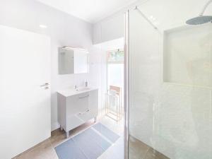 a white bathroom with a shower and a sink at Capelas House Family in Capelas +39 photos