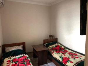 a small room with two beds and a table at Shahina tur service in Samarkand