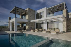 a house with a swimming pool in front of it at Crete Villa Paseathea, Luxurious Pool Getaway in Kamilari