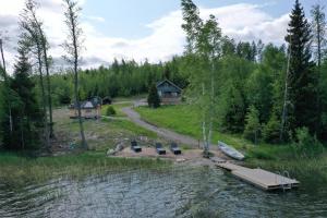un lago con una casa, un muelle y un barco en Villa Granbacka Raasepori Karjaa Finland, en Karjaa