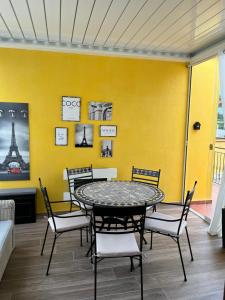 una mesa y sillas en una habitación con una pared amarilla en Nella natura a due passi dal mare a casa di Francy, en Numana