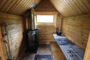 an inside view of a wooden cabin with a stove at Villa Granbacka Raasepori Karjaa Finland in Karjaa