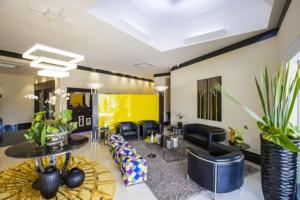a living room with black furniture and a yellow wall at Intercity Vinhedo in Vinhedo