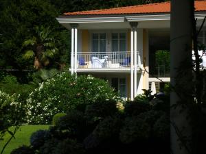 una casa con un balcón en el lateral. en Ville Lago Lugano, en Porto Ceresio