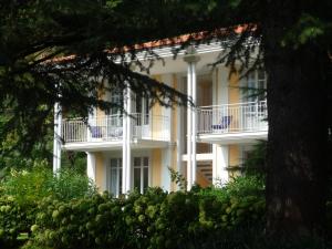 a large white building with white columns and balconies at Ville Lago Lugano in Porto Ceresio