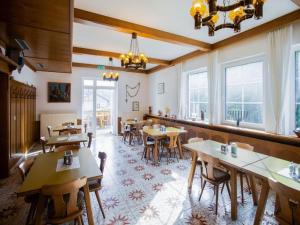 un restaurante con mesas y sillas de madera y ventanas en Gasthof Wabitsch, en Kliening