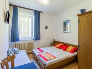 Schlafzimmer mit einem Bett mit roten Kissen und einem Fenster in der Unterkunft Gasthof Wabitsch in Kliening
