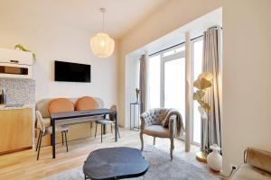 - un salon avec un bureau et une table dans l'établissement Charming 1-BEDR Parisian Apartment in Vibrant Rue d'Hauteville, à Paris