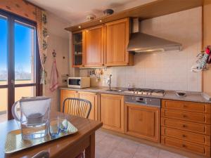 uma cozinha com armários de madeira e uma bancada em Il Bosco di RE guesthouse, camera matrimoniale em Reggio Emilia