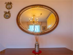 uno specchio su un muro con un vaso su un tavolo di Il Bosco di RE guesthouse, camera matrimoniale a Reggio Emilia