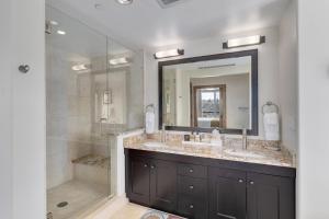 a bathroom with a shower and a sink and a mirror at Edgemont 2601 - Luxury Ski-in Ski-out Condo in Steamboat Springs +12 photos