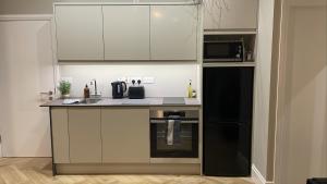 a kitchen with a black refrigerator and a microwave at CityGo Apartments Queens in Belfast