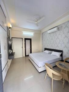 een slaapkamer met een bed en een tafel en stoelen bij Hotel Grand Mala in Jaipur