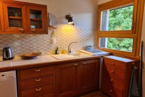 una cocina con armarios de madera y fregadero en Apartment with view of Prorel en Briançon