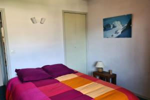 1 dormitorio con 1 cama con una manta colorida en Apartment with view of Prorel, en Briançon