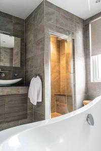 a bathroom with a tub and a glass shower at The Canoeists Hideaway in Seaton Carew