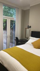 Schlafzimmer mit einem Bett und einer Glasschiebetür in der Unterkunft CityGo Apartments Queens in Belfast