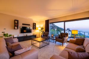 a living room with a couch and chairs and a tv at Villa Butterfly in Fethiye