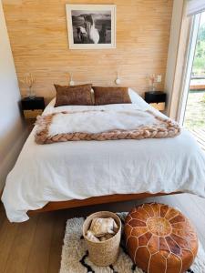 Un dormitorio con una cama grande y una ventana en Confortable refugio de monataña con vista al Volcan, en Malalcahuello