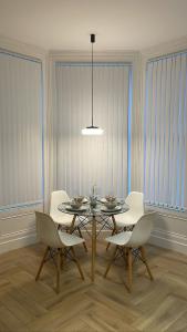 a dining room with a table and white chairs at CityGo Apartments Queens in Belfast