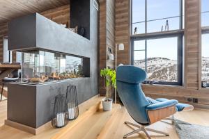 a living room with a blue chair and a fireplace at Rindabakkane Lodge in Sogndal