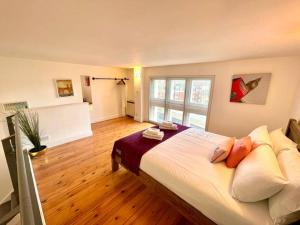 a bedroom with a large bed in a room at High-Ceiling Flat with Rooftop & Skyline View in London