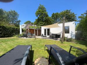 einen Blick auf den Hinterhof eines Hauses mit einer Terrasse in der Unterkunft Nature & golf Villa in Oosterhout