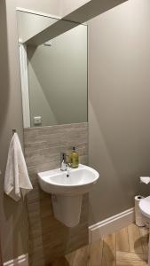 a bathroom with a white sink and a mirror at CityGo Apartments Queens in Belfast