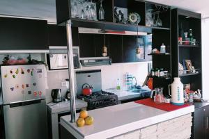 a kitchen with black cabinets and a white refrigerator at Departamento: Mirador de Puno. in Puno