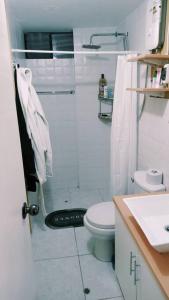 a white bathroom with a shower and a toilet at Departamento: Mirador de Puno. in Puno