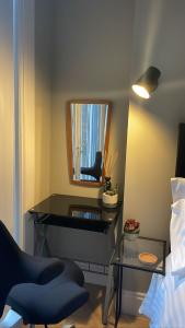 Zimmer mit einem Spiegel, einem Stuhl und einem Tisch in der Unterkunft CityGo Apartments Queens in Belfast
