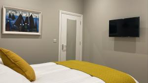 a bedroom with a bed and a flat screen tv at CityGo Apartments Queens in Belfast