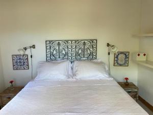 um quarto com uma grande cama branca e 2 almofadas em Casa do Mangue-Paraíso na beira do rio Wi-Fi 300 M em Jaguaripe