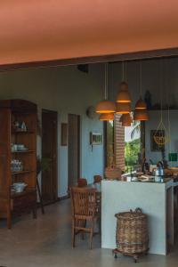 uma cozinha e sala de jantar com mesa e cadeiras em Casa do Mangue-Paraíso na beira do rio Wi-Fi 300 M em Jaguaripe