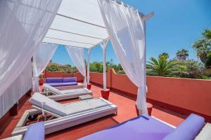 un balcón con camas y sillas en el techo en Villa Tiphareth, en Marbella