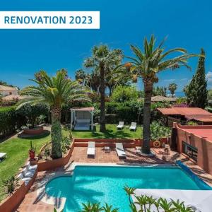 uma villa com piscina e palmeiras em Villa Tiphareth em Marbella