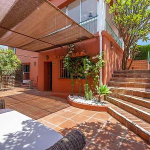una casa naranja con escaleras y porche en Villa Tiphareth, en Marbella