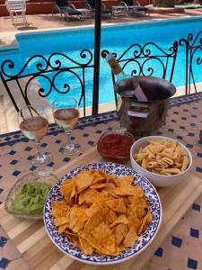 una mesa con un plato de nachos y salsa en Villa Tiphareth, en Marbella