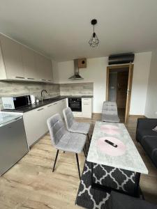 eine Küche und ein Wohnzimmer mit einem Tisch und Stühlen in der Unterkunft Apartamenty Wadowity- Energylandia Zator in Wadowice