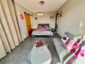 uma sala de estar com uma cama e um sofá em Villa / Maison indépendante 150m de la plage avec jacuzzi et piscine chauffée à Saint Cyprien plage em Saint-Cyprien