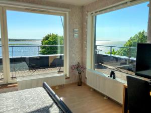 a room with a large window with a view of the water at Sunset Dream Apartment with a panoramic seaview in Haapsalu