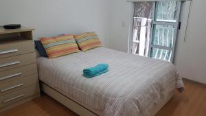 a bed with a blue towel on top of it at Santa Clara Residence bedrooms in Rio de Janeiro