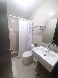 uma casa de banho branca com um WC e um lavatório em Cubao Manhattan HEights Unit 6H Tower B, 2BR em Manila