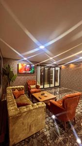 a living room with couches and a table and a tv at Melissa Suite Otel in Trabzon