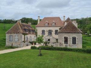 una vieja casa de piedra con dos chimeneas en un campo en Château de Paraize, en Livry