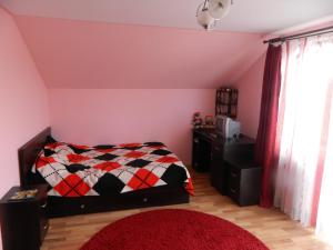1 dormitorio con 1 cama con manta a cuadros en Villa Blacky en Cluj-Napoca