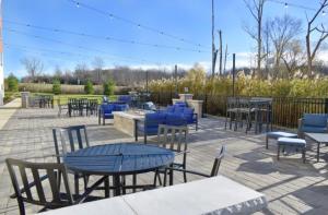 a patio with tables and chairs and blue chairs at Holiday Inn Express & Suites - Madison by IHG in Madison