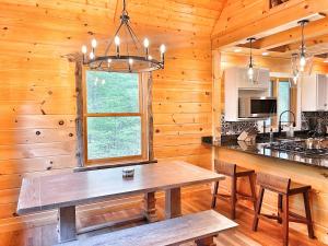 a kitchen with a table and a window in a cabin at Luxury ADK Retreat Near Whiteface, Lake Placid in Jay
